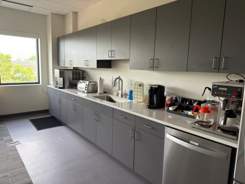 Staff kitchen with gray cabinets and coffee equipment