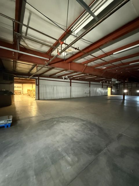 Open warehouse with red steel roof framing