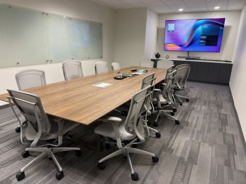 Conference room with wood table and wall display