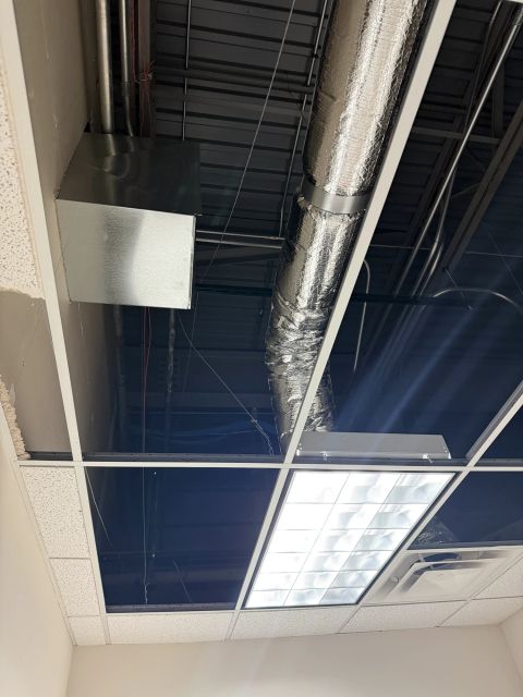 Insulated duct branch above a partially open ceiling