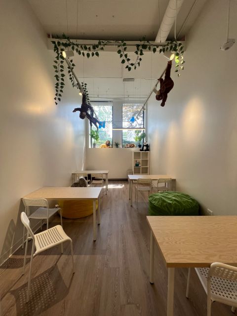 Jungle-themed activity room with tables and soft seating
