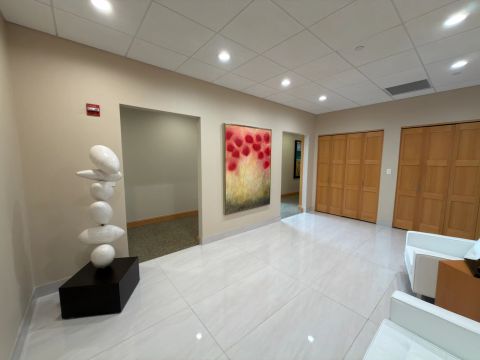 Lobby artwork and sculpture beside wood entry doors