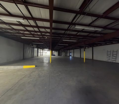 Open warehouse with red roof beams and yellow columns
